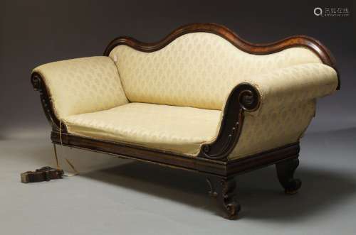 A Victorian mahogany framed sofa, with serpentine shaped backrest and scrolling carved armrests,