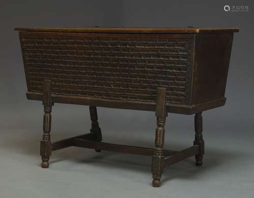 An elm chip carved chest, 19th Century, of tapered form, the hinged lid enclosing storage space