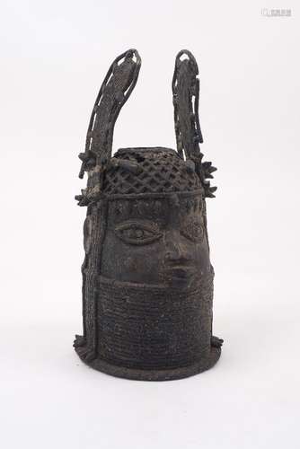 A Benin bronze head of an Oba, 20th Century, with a winged headdress, latticed coiffure with