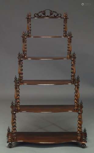 A Victorian rosewood six tier whatnot, with six graduated serpentine tiers, on spiral turned