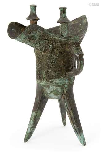 A Chinese archaic bronze ritual wine vessel, jue, Shang dynasty-style, the deep U-shaped body raised