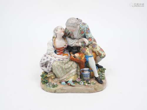 A Dresden porcelain figural group of a couple courting, decorated in the Meissen style with floral