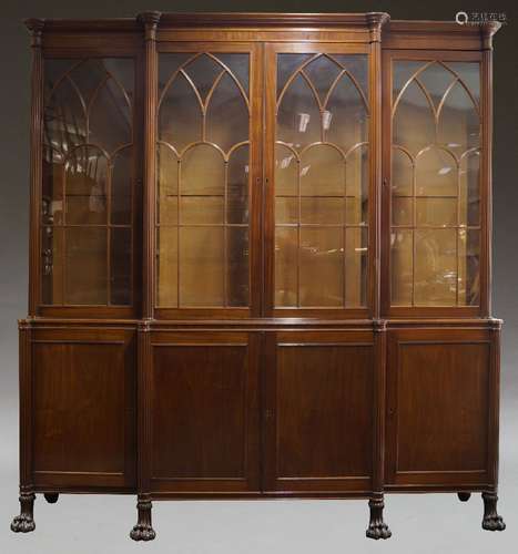 A mahogany breakfront bookcase, early 19th Century, the moulded cornice above four Gothic arch