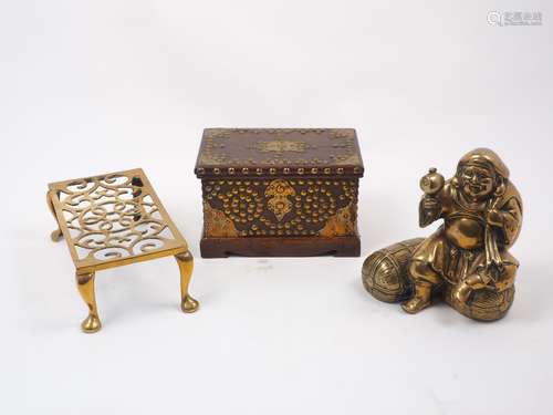 A brass rectangular trivet of pierced form, together with a brass door stop modelled as an Asian