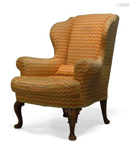 A George III style wingback armchair, first half 20th Century, with serpentine wings, upholstered in