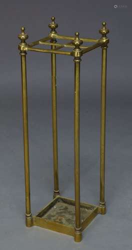 An Edwardian brass stick stand, with finialed top, having four divisions, raised on cylindrical