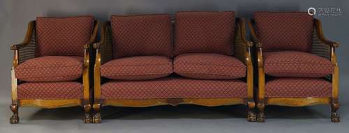 A walnut and caned three piece suite, early 20th Century, to include a two seat sofa, 77cm high,