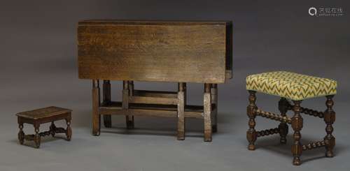 A George III oak gate leg table, with two drop leaves, with frieze drawer to one end, raised on