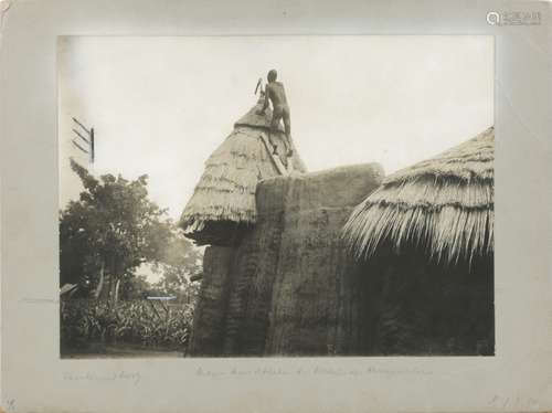 Early 20th Century, German School, a native African man climbing on a roof, photograph on board,