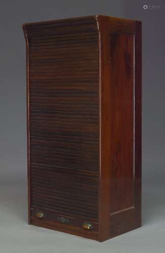 An Edwardian mahogany tambour fronted cabinet, the tambour shutter enclosing three shelves, 122cm