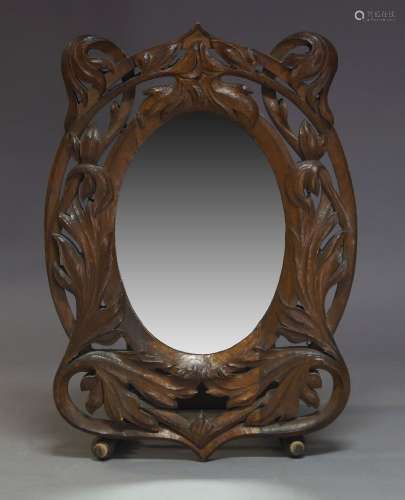 A carved oval wall mirror, 20th Century, with oval plate set within pierced and foliate carved