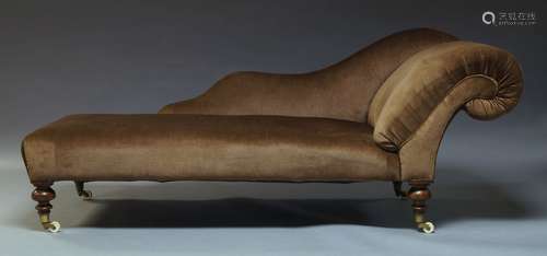 A Victorian Chaise Longue, with serpentine backrest and scrolling end, upholstered in brown velvet