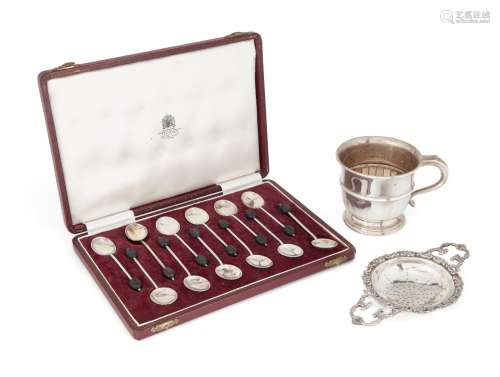 A silver tea strainer, London, c.1958, William Comyns & Sons., with stylised scroll handles and