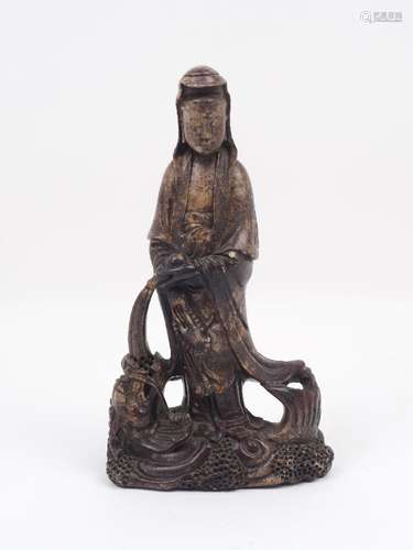 A soapstone figure of Guanyin, 20th century, carved pouring water into a dragon's mouth, 29cm