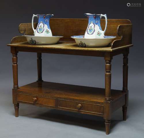 A Victorian mahogany washstand, the top with raised back and sides, the top surface with two