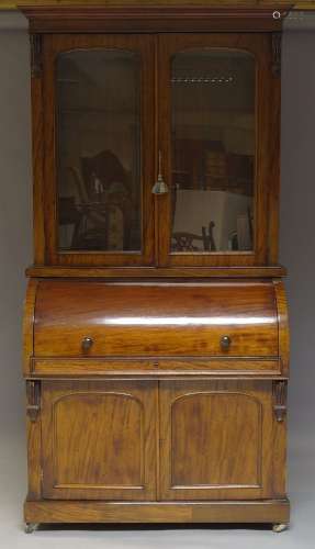 A Victorian mahogany cylinder secretaire bookcase, the moulded cornice above two glazed doors,