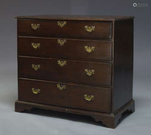 A George III oak and crossbanded chest of drawers, with four long graduated drawers, raised on