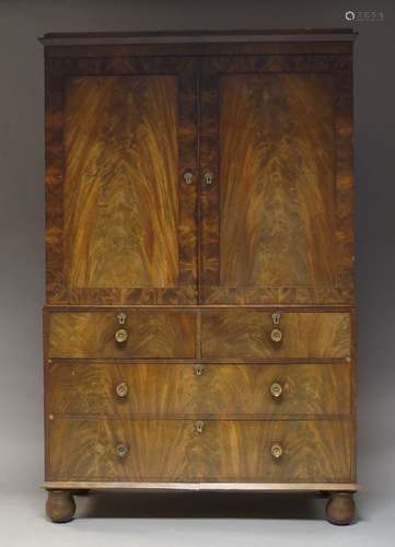 A Victorian flame mahogany linen press, the moulded cornice above two panelled doors, enclosing four