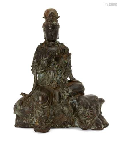 A Chinese bronze figure of Guanyin atop and elephant, late Qing dynasty, Guanyin modelled seated