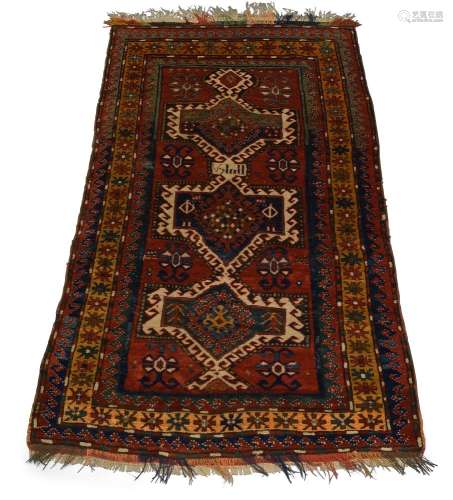 A Kazak rug, mid 20th Century, the red field with three lozenge panels and a signature panel, with