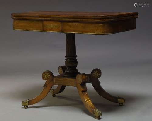 A Regency rosewood and brass inlaid card table, the fold over top enclosing green baize lined