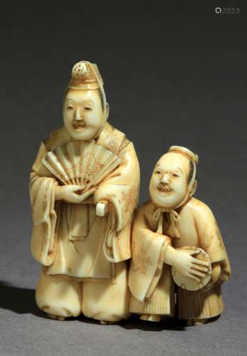 Netsuke japonés siglo XIX.明治时期。Firmado Mitsuraku en un lateral.在大理石纹上代表着一个演员的形象，其中一个人举着一个abanico abierto和catana，另一个人举着一个tambor，45,30x31,40x20,10 mm.16,12 gr.Mateu Guillermo。在Mateu Guillermo公开。