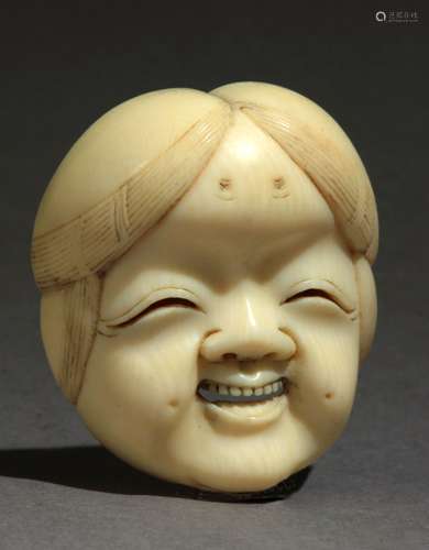 Netsuke japonés finales siglo XIX.明治时期。牢固在一个汉字的绿色在三层的部分。在代表Okame sonriente的大写字母的大理石上，35x30,6x17,1毫米。9,21克。这是由西班牙反盗墓者联合会（Federación Española de Anticuarios）所提供的珍贵文件的附件。十九世纪末日本明治时期的净水壶。背面有绿色汉字签名。雕象牙，刻有微笑的大龟面具，35x30,6x17,1毫米。9,21克。附西班牙古董商联合会的专家报告。