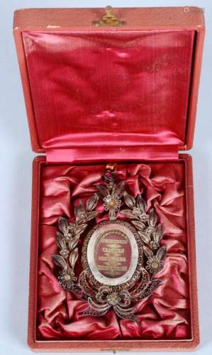 小盒子里装着一个镀银和镂空金属的椭圆形遗物，中间有四件不同圣徒的遗物。奖章高度：+/- 10厘米。