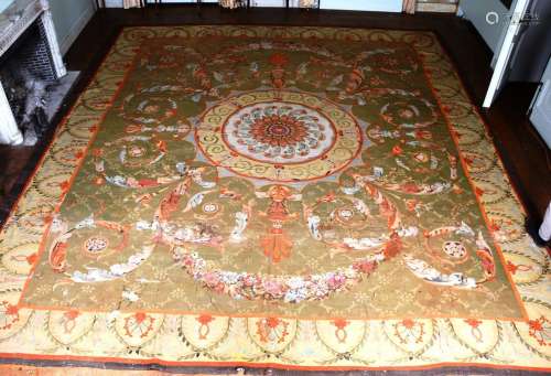 奥布松地毯（羊毛经纬），法国复古时期。这块大地毯的装饰是在青铜绿背景上的中央多色玫瑰花，并饰以花环。象牙色的边框上有小花章环绕着构图。磨损，旧的修复和腐烂的零件 。尺寸：600 cm x 540 cm