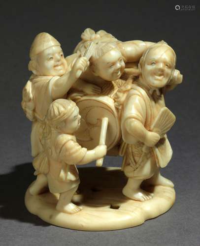 Netsuke Okimono japonés finales siglo XIX.明治时期。牢固的Munekazu在LA基地。用大理石装饰，代表着两个孩子在玩耍的时候和两个男人在一起玩耍的场景，53,90x42,40x46,30毫米.63,76克。一件19世纪末的日本明治时期的网红和服。底座上有Munekazu的签名。雕刻的大象象牙描绘了一组由两个孩子组成的人物，两个男人肩上扛着鼓，53,9x42,4x46,3毫米，63,76克。63,76克，附有西班牙古董商联合会的专家报告。