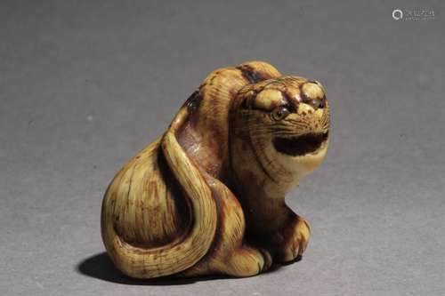 Netsuke japonés principios Siglo XIX.江户时期。Firmado Hogen Rantei在一个侧面。在大理石壁画上，用硬壳印着代表虎皮的虎皮，向着前面的方向，在其上有可乐，29,5x34,4x31,8 mm.21,18 gr.Publicado en Mateu Guillermo.