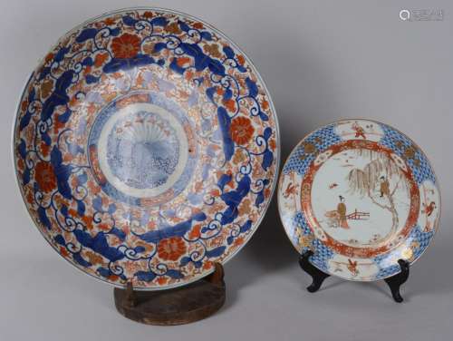 日本：一组两件伊玛里装饰的多色瓷器。1/ 碟子上有交错的装饰和叶子及花卷。19世纪。直径：46厘米2/盘面上有湖泊装饰和人物保留在翅膀上。十九世纪。直径：27厘米