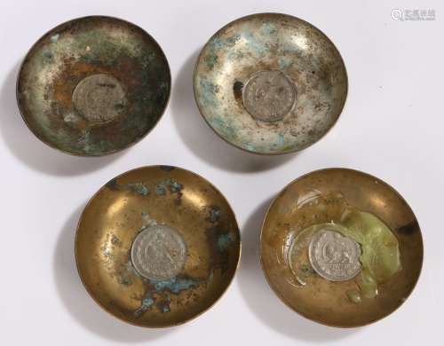 Set of four silver plated and brass Middle Eastern dishes, with coin inset bases and foliate