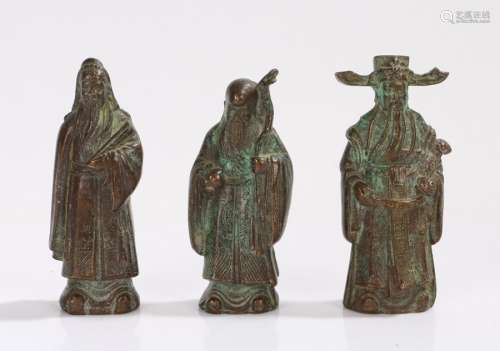 Three Oriental cast metal figures, to include figure holding a stick and orb, 8.5cm high (3)