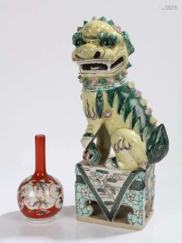 Chinese dog of fo, modelled in a seated position, standing on a pierced foliate and bird decorated