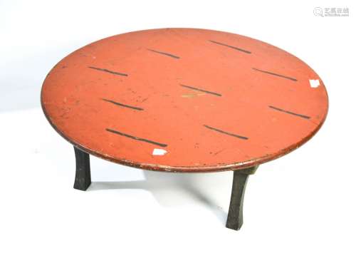 An antique Chinese table painted red and on raised four splayed legs, 24cm by 66cm