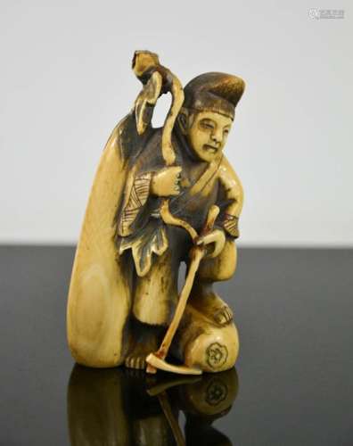 A Chinese carved ivory figure holding a stick, signed to the base, circa 1900, 8cm high.