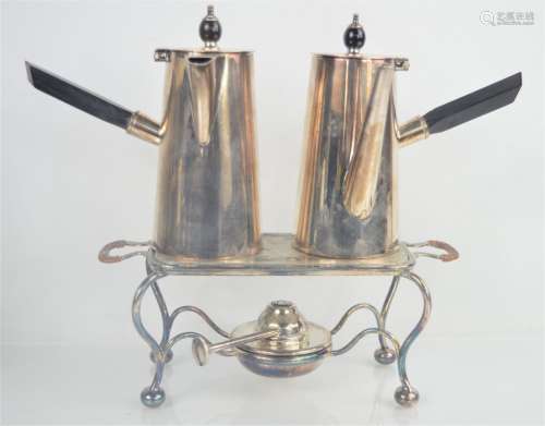 A pair of chocolate pots with ebonised handles together with a warming plate and burner by Asprey of