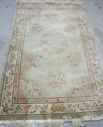 A modern Chinese wool rug with pale green ground decorated with flowers,155cm x 245cm