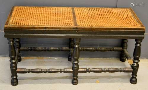 An antique long stool with cane work seat, and turned legs, 45 by 91 by 40cm.