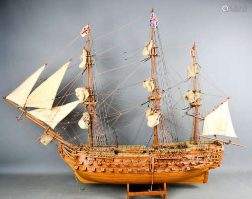 A vintage wooden hand made battle ship, flying British and English flags, complete with sails,