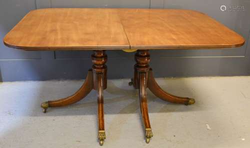 A Regency mahogany twin pedestal dining table, with an extra leaf, 104cm by 74cm by 149cm without