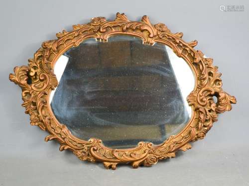 An oval gold painted plasterwork mirror, 67 by 48cm.