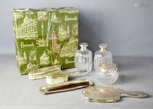 An eight piece white metal dressing table set, comprising pair of cut glass flagons, powder bowl,