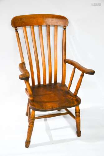 A Victorian kitchen armchair, with slatted back, moulded seats and raised on turned legs united by