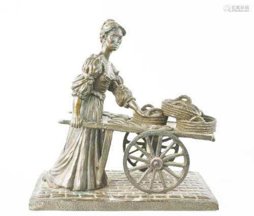 A bronze style model of a female seller with a cart. 33cms tall x 16cms wide x 32cms long
