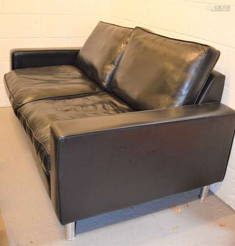 A black leather modern two seater settee raised on chrome feet, 94cm by 182cm by 100cm.