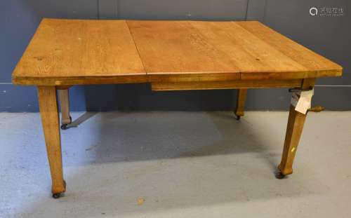 An oak extending dining table with winder, 147cm by 104cm by 74cm