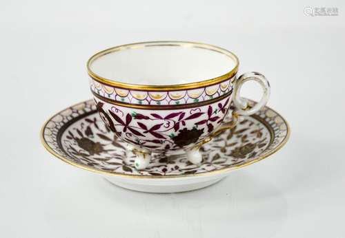 A 19th century German porcelain cup and saucer, decorated with purple flowers and gilded highlights,