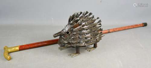 A cast metal garden ornament in the form of a Hedgehog, 22cm high, together with a walking stick.